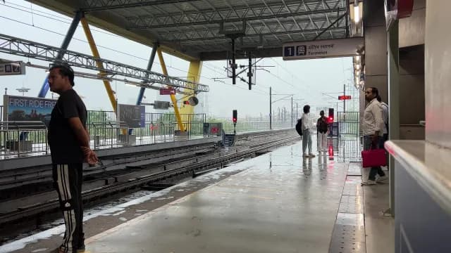 Passengers Waiting at a Rain-Slicked Metro Station Platform in India