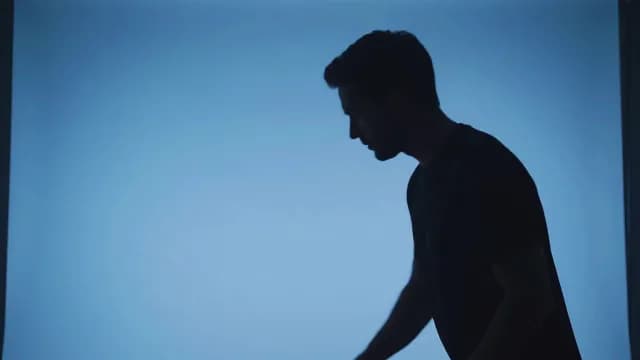 Pensive Man Silhouette Profile Against Blue Studio Background