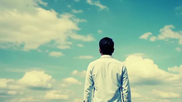 Man Looking at Bright Blue Sky with White Clouds