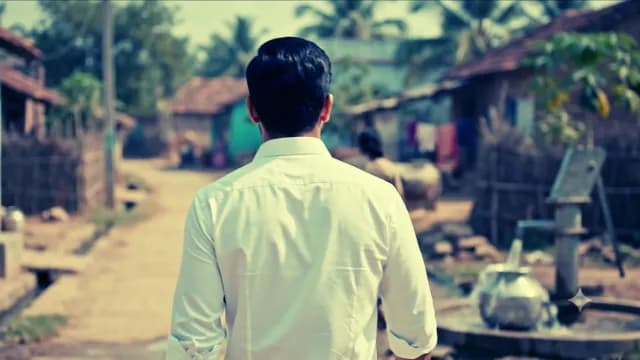 Man in White Shirt Walking Through Rural Village Street