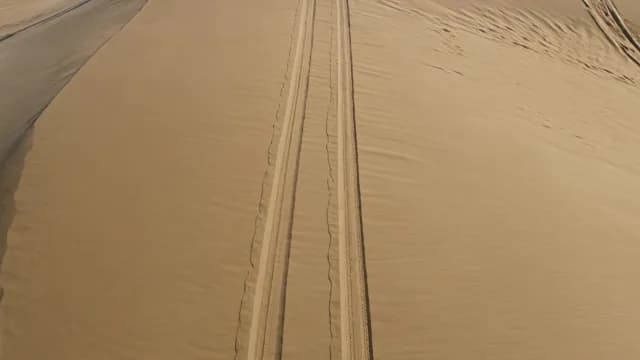 Aerial View of Tire Tracks in Vast Desert Sand Dunes