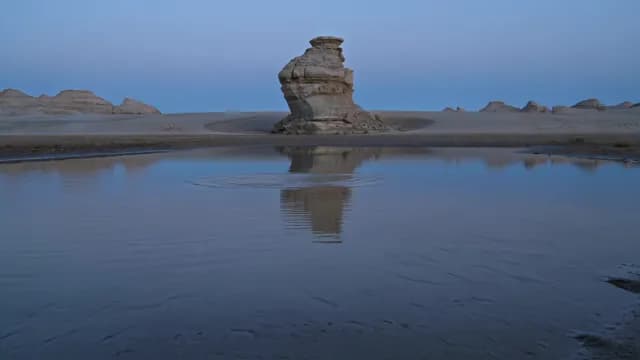 Limestone Rock Formation Reflecting in Desert Water at Twilight
