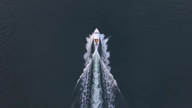 Aerial Top Down View of Speedboat Cruising Deep Blue Sea