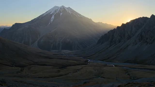 Sunrise Over Majestic Snow-Capped Mountain and Rugged Valley