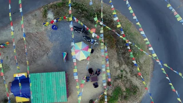 Aerial View of a Roadside Tea Stall with Buddhist Prayer Flags