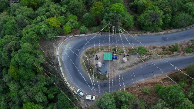 Aerial View of Mountain Hairpin Turn with Buddhist Prayer Flags in Mussoorie