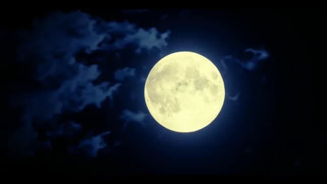 Glowing Full Moon in Dark Night Sky with Atmospheric Clouds