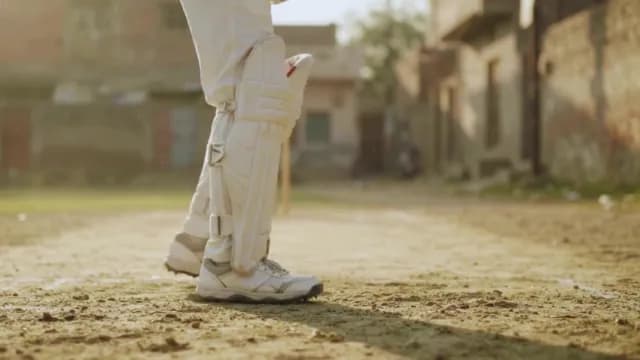 Cricket Batsman in Protective Gear on Outdoor Pitch