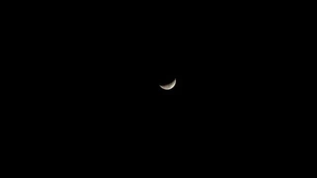 Glowing Crescent Moon in Pitch Black Night Sky