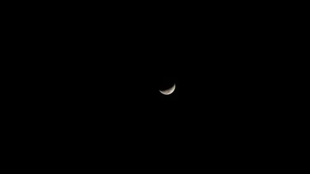 Slender Crescent Moon Glowing in Dark Night Sky