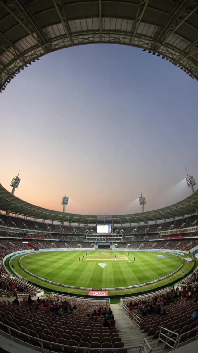 Wide Angle Cricket Match at Sunset in Modern Stadium