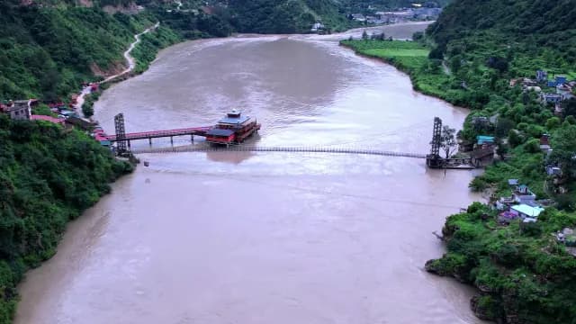 Aerial View of Long Suspension Bridge Over Mountain River