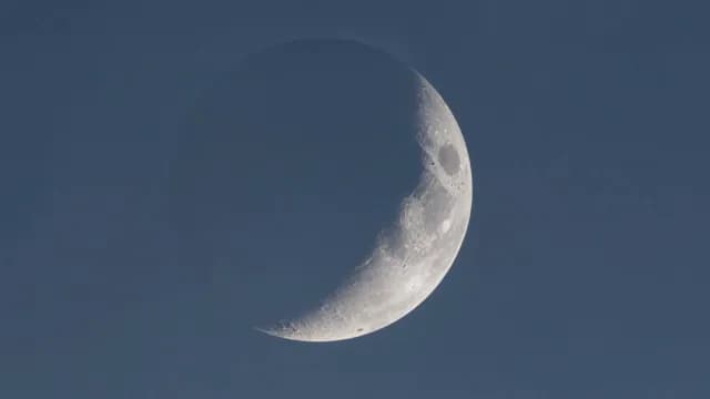 Detailed Crescent Moon in Clear Blue Daytime Sky