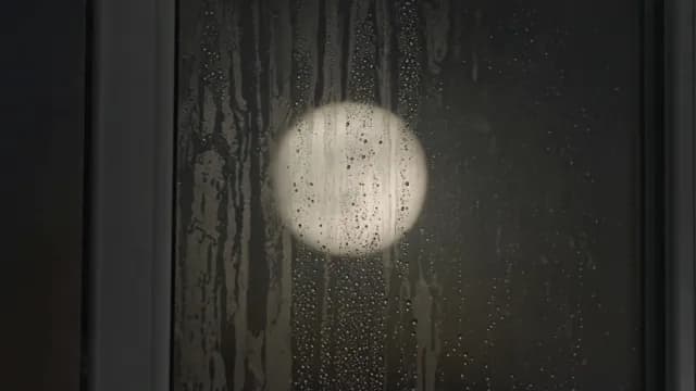 Full Moon Glowing Through Foggy Window at Night