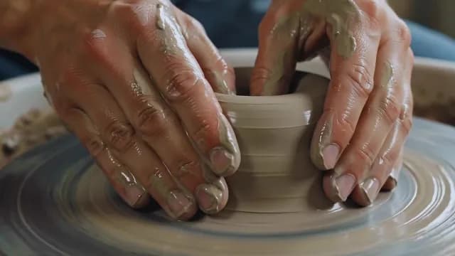 Close-Up of Potter's Hands Shaping Clay on Spinning Pottery Wheel
