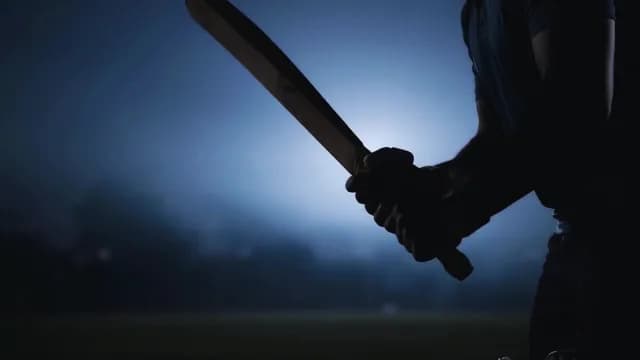 Dramatic Silhouette of a Cricket Batsman Holding Bat at Night