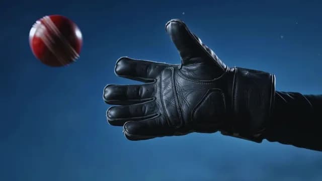 Close-Up Shot of Cricket Wicket-Keeper Catching a Spinning Red Ball