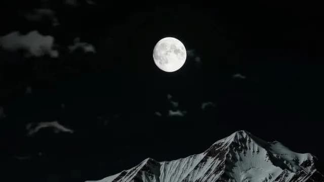 Full Moon Shining Over Snowy Mountain Peak at Night
