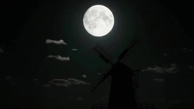 Silhouette of Traditional Windmill Under a Large Glowing Full Moon