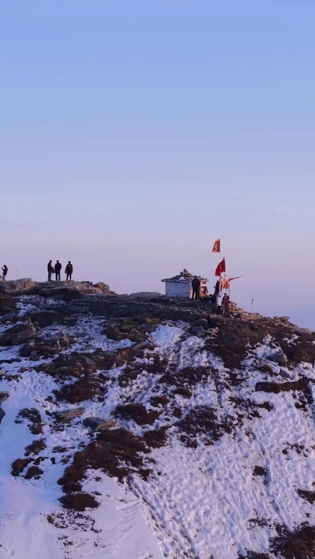 Hikers at a Mountain Peak Shrine During Sunrise in the Chandrashila Peak and Himalayan Mountains in Chopta, Uttarakhand