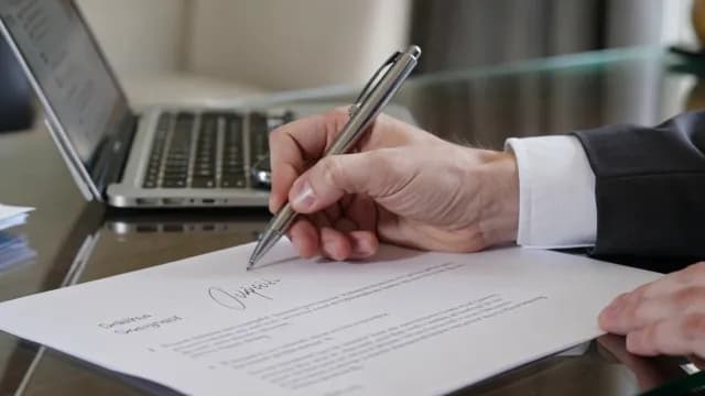 Businessman Signing Official Contract Document in Modern Office