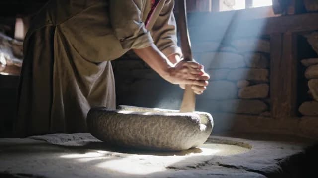 Traditional Stone Grinding of Grains in Rustic Sunlight