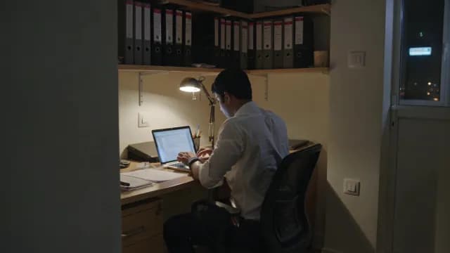 Focused Businessman Working Late on Laptop in Home Office