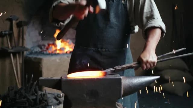 Blacksmith Hammering Glowing Red Hot Metal on Anvil in Forge