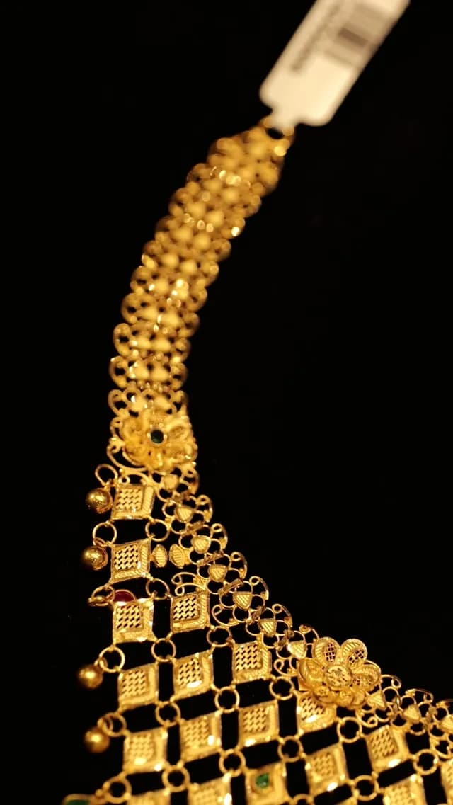 Elegant Intricate Gold Necklace with Floral Details on Black Background