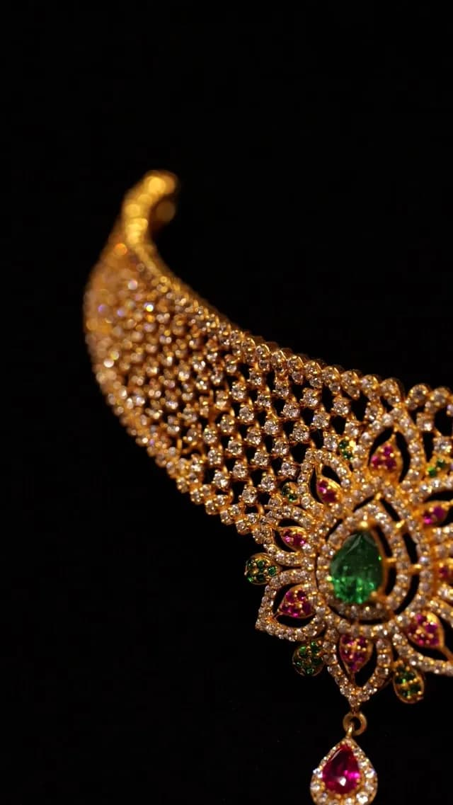 Elegant Gold Necklace with Diamonds Emeralds and Rubies on Black Background