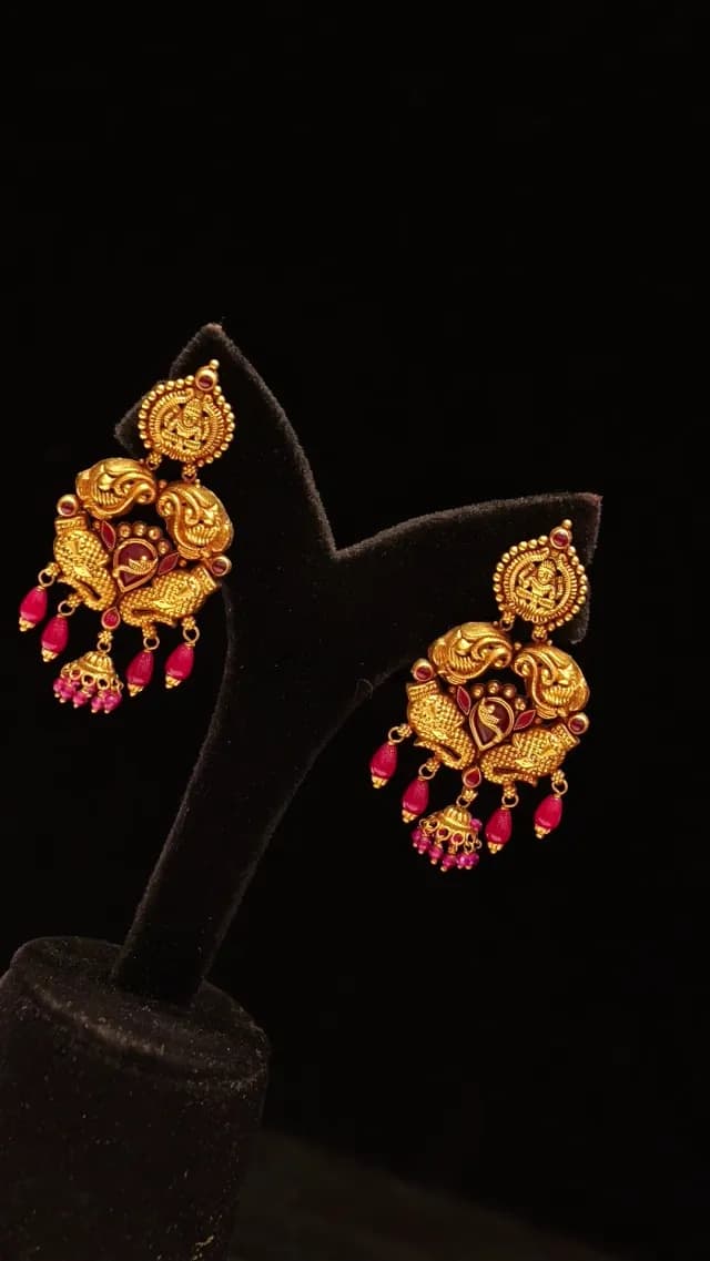 Traditional Indian Gold Temple Earrings with Red Gemstones on Black Stand