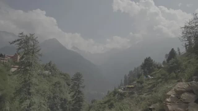 Scenic Mountain Valley View with Lush Greenery and Hazy Peaks at Snowpeak mountains view from Tosh Village, Himachal Pradesh