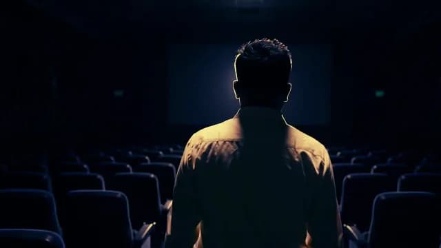 Silhouette of a Man Standing in an Empty Dark Movie Theater