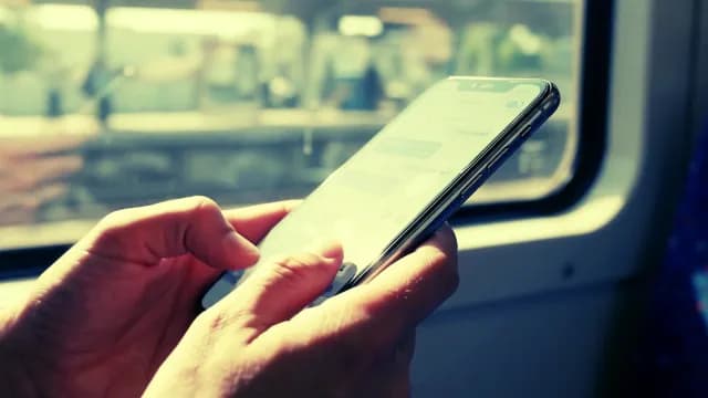 Person Texting on Smartphone While Commuting on a Train