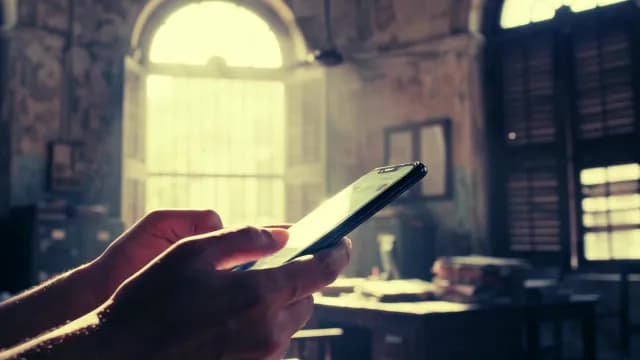 Close-up of Hands Using Smartphone in a Sunlit Vintage Room