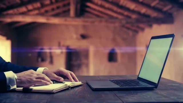 Businessman Working with Laptop and Notebook in Rustic Interior Office