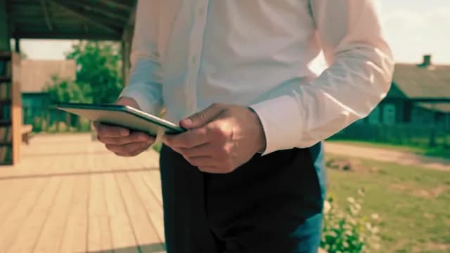 Professional Man Using Digital Tablet Outdoors in Rural Setting