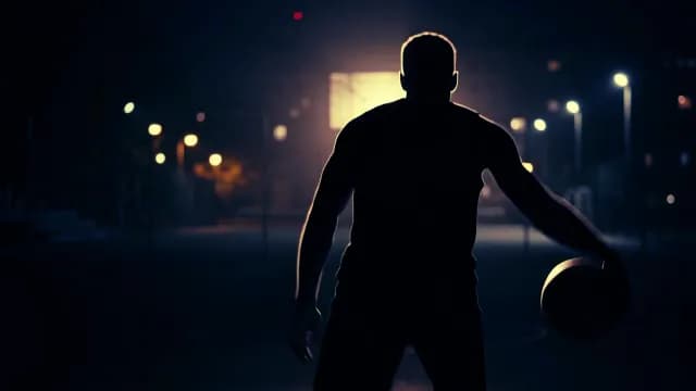 Silhouette of Basketball Player Training on Outdoor Court at Night