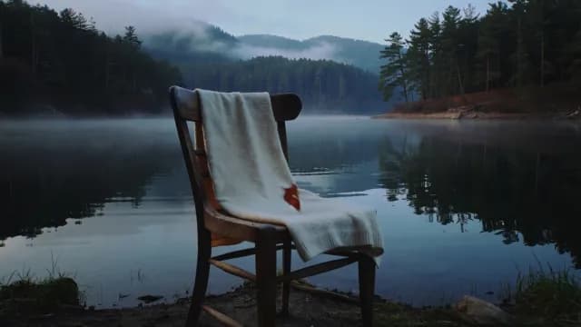 Peaceful Morning Scene with Wooden Chair by Misty Lake