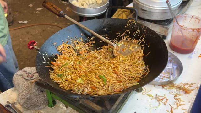 Street Food Chef Cooking Stir-Fried Noodles in a Large Wok