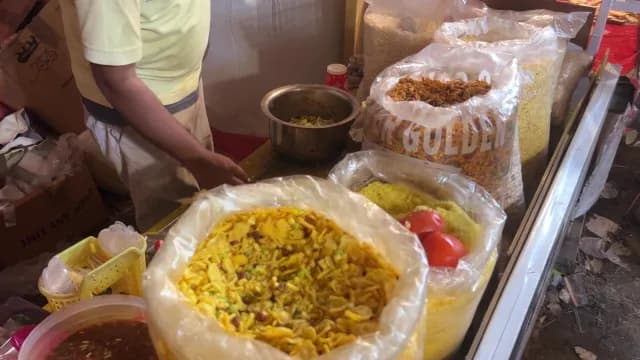 Indian Street Food Vendor Preparing Traditional Savory Snacks at a Market Stall